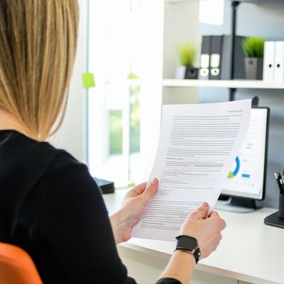 patient holding paper at front desk of office-1