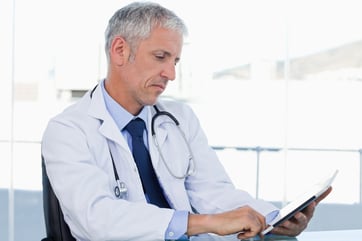 Doctor working with a tablet computer in his office