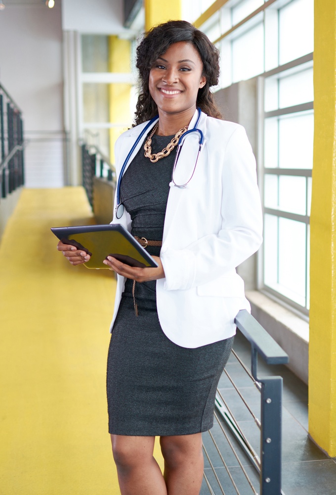 Portrait of a female doctor holding her patient chart on digital tablet in bright modern hospital-2.jpeg