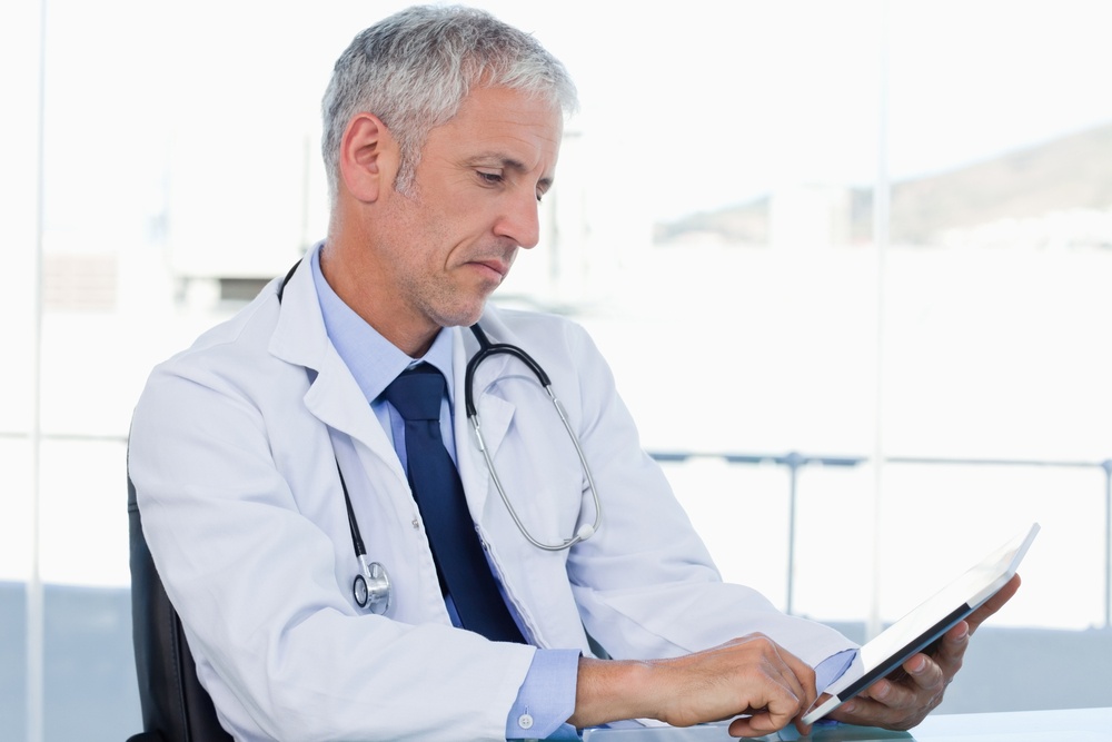 Doctor working with a tablet computer in his office